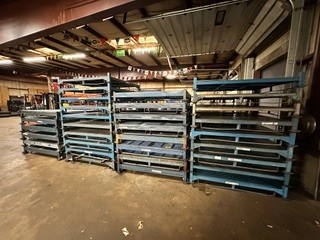 Stacked disassembled stack rack units showing frame construction and metal components