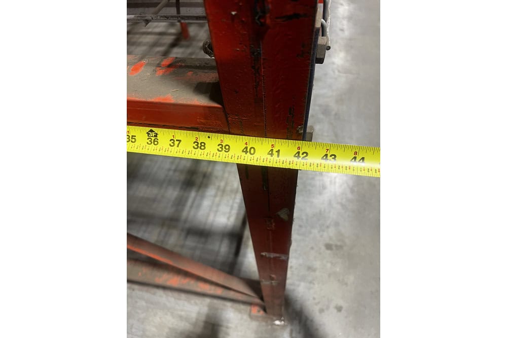 42 inch wide structural pallet rack frame depth measured with tape measure showing column spacing